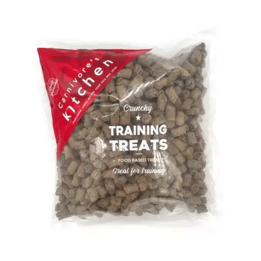 Carnivores Kitchen Crunchy Training Treats in a clear bag, showcasing small, brown, pellet-shaped bites ideal for mess-free, frequent pet training and enrichment activities.