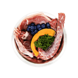 Stainless-steel bowl with True Carnivores' 100 Mile Raw Duck Dinner: raw duck, beef heart, liver, kidney, tripe, kale, pumpkin, blueberries. Ideal for active dogs.