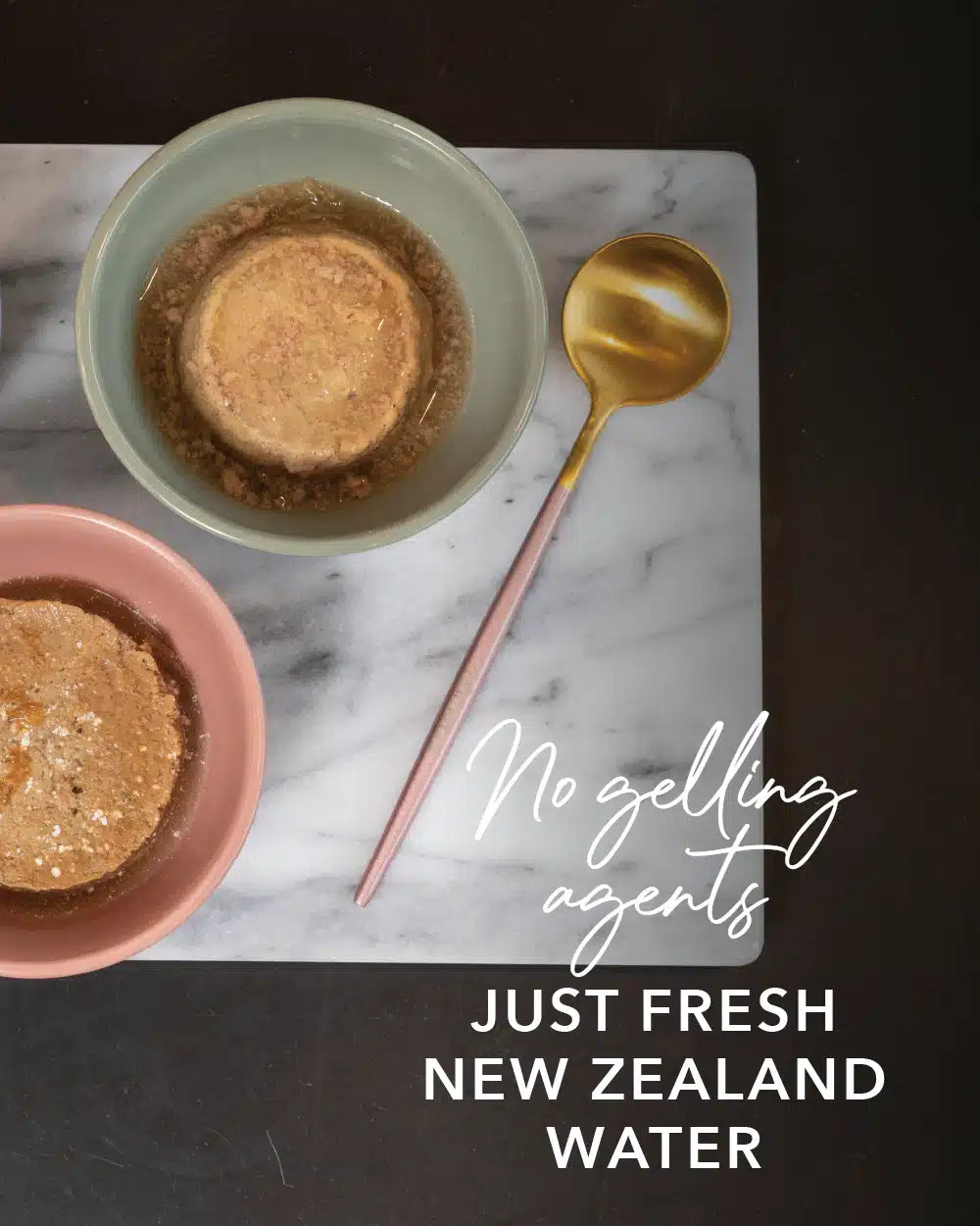 Feline Natural Canned Food for Cats displayed on a marble board with pastel bowls, highlighting protein-rich, hydrating jelly-like pudding and gold-tone spoon.