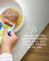 A person squeezes Feline Natural Pouches - Variety Box into a bowl, emphasizing its additive-free, high-protein, moisture-rich nutrition for cats.