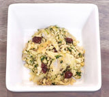 Tom & Sawyer Fisherman's Best Friend, a bowl of riced cauliflower salad with onions, herbs, dried berries, and nuts, designed as a nutritious, fish-forward dog meal.