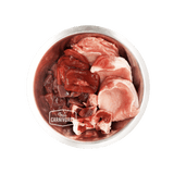 Metal bowl with raw pork cuts and organs, branded True Carnivores, showcasing 100 Mile Raw Just Pork, a locally sourced, boneless pet food mix.