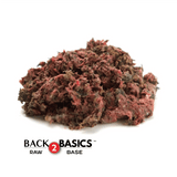 Back 2 Basics Pure Whole Prey Quail (Ground) - 1lb Portions; a mound of ground quail meat with feathers, ideal for pet meals.