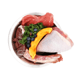 Stainless steel bowl of 100 Mile Raw Turkey Dinner with raw turkey, beef organs, kale, pumpkin, and blueberries, branded True Carnivores for pets.