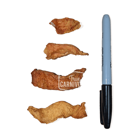 One Ingredient Air-Dried Pumpkin: Four thin, dehydrated pumpkin strips, soft and chewy, beside a marker for scale, ideal low-calorie, high-fiber dog treats.