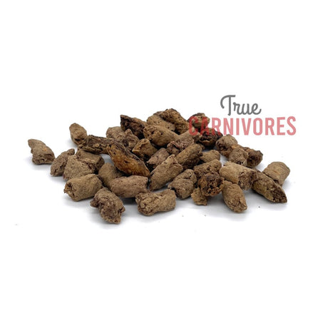 Carnivores Kitchen Crunchy Training Treats are small, irregularly-shaped brown pellets, perfect for training carnivorous pets with mess-free, high-protein rewards.