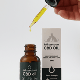 Carnivore Care Organic Full Spectrum Hemp Oil for pets, featuring a brown dropper bottle with a dropper and white box labeled for dogs and cats, 1000mg.