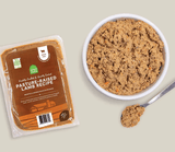 Open Farm Gently Cooked Pasture-Raised Lamb Recipe pouch beside a bowl with lamb-and-vegetable pâté, illustrating a human-grade, grain-free dog food option.