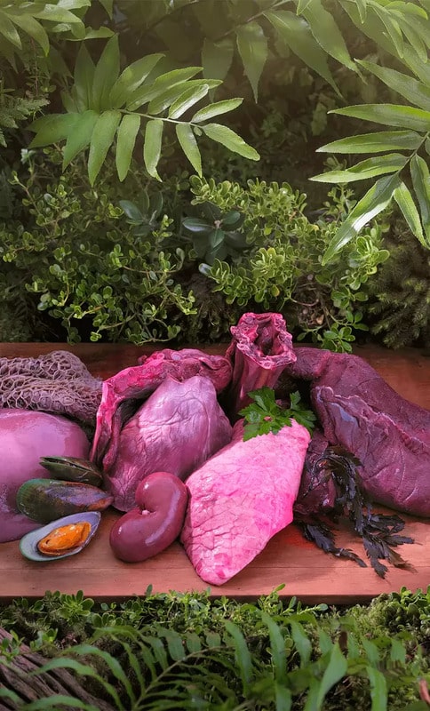 Ziwi Peak Venison for Dogs displayed as raw offal cuts, including tripe and kidneys, on a wooden plank, emphasizing natural, high-meat content.