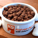 K9 Natural Freeze-Dried Beef Feast for Dogs in a pet bowl, showcasing small brown kibble nuggets, ready to serve dry or rehydrated for convenience.