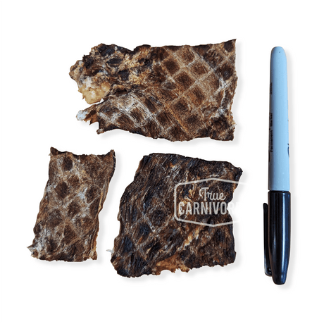 One Ingredient Kangaroo Steak 100g features three dried kangaroo muscle slabs beside a marker for scale, showcasing a hypoallergenic, high-protein pet treat.
