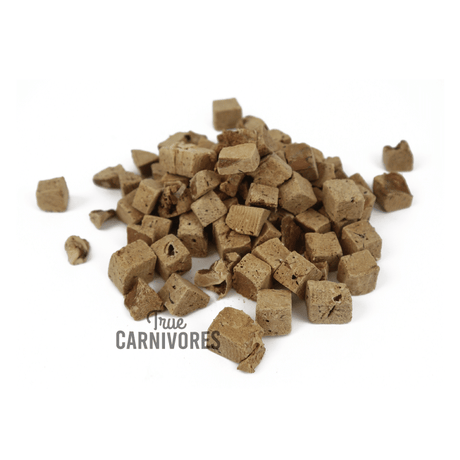 Pile of small, cube-shaped One Ingredient Freeze-Dried Pork Liver Bites, showcasing the True Carnivores logo, ideal for pet training or as meal toppers.