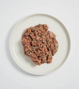 Rawbone Mixed Protein Pork Meal on a white plate, showcasing raw ground pork mixed with herbs and vegetables for a nutritious, ready-to-serve pet meal.