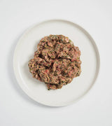 Rawbone Mixed Protein Turkey Meal: Overhead view of raw minced turkey with beef organs and herbs, presented on a white plate for species-appropriate nutrition.